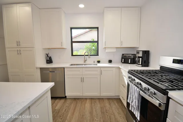 a kitchen with a sink stove and white cabinets