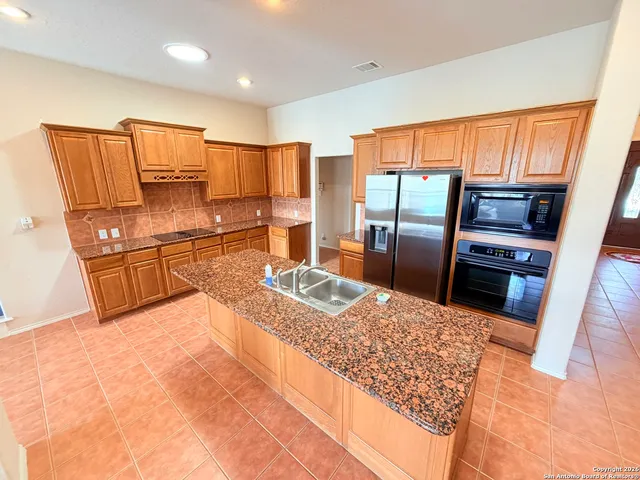 a kitchen with stainless steel appliances granite countertop a refrigerator and a sink