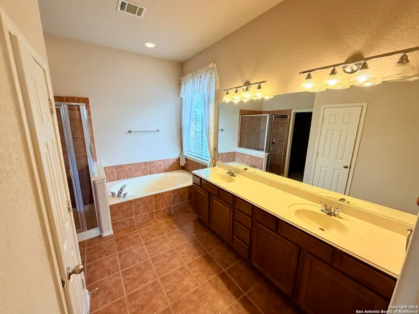 a bathroom with a double vanity sink and mirror