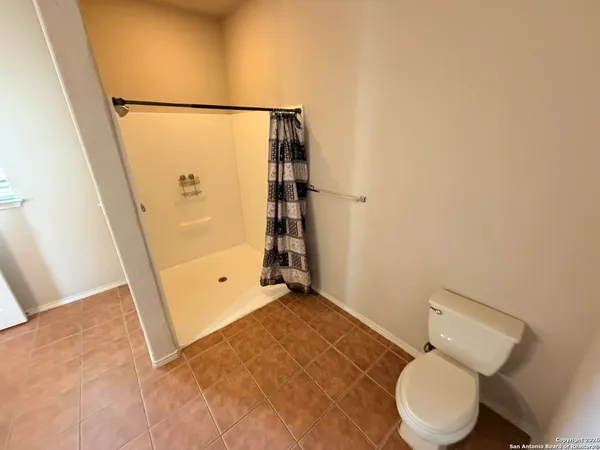 a bathroom with a toilet and a shower