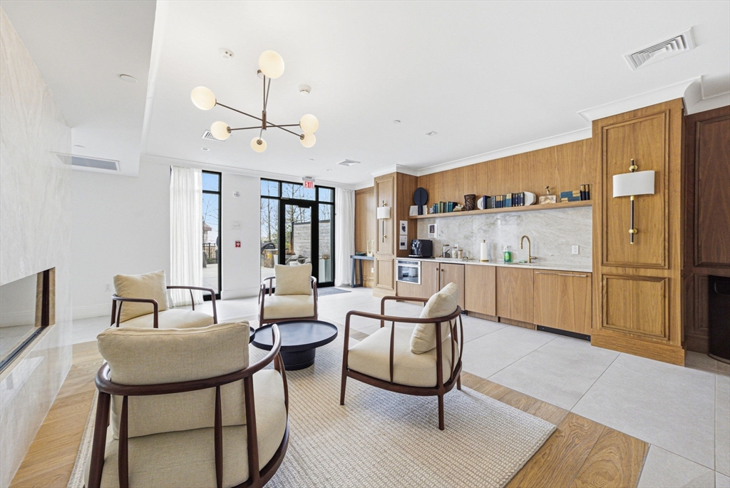 191 Washington Street, Unit 413 Boston, MA 02135 - Photo 11 of 40 a living room with stainless steel appliances kitchen island granite countertop furniture and a kitchen view