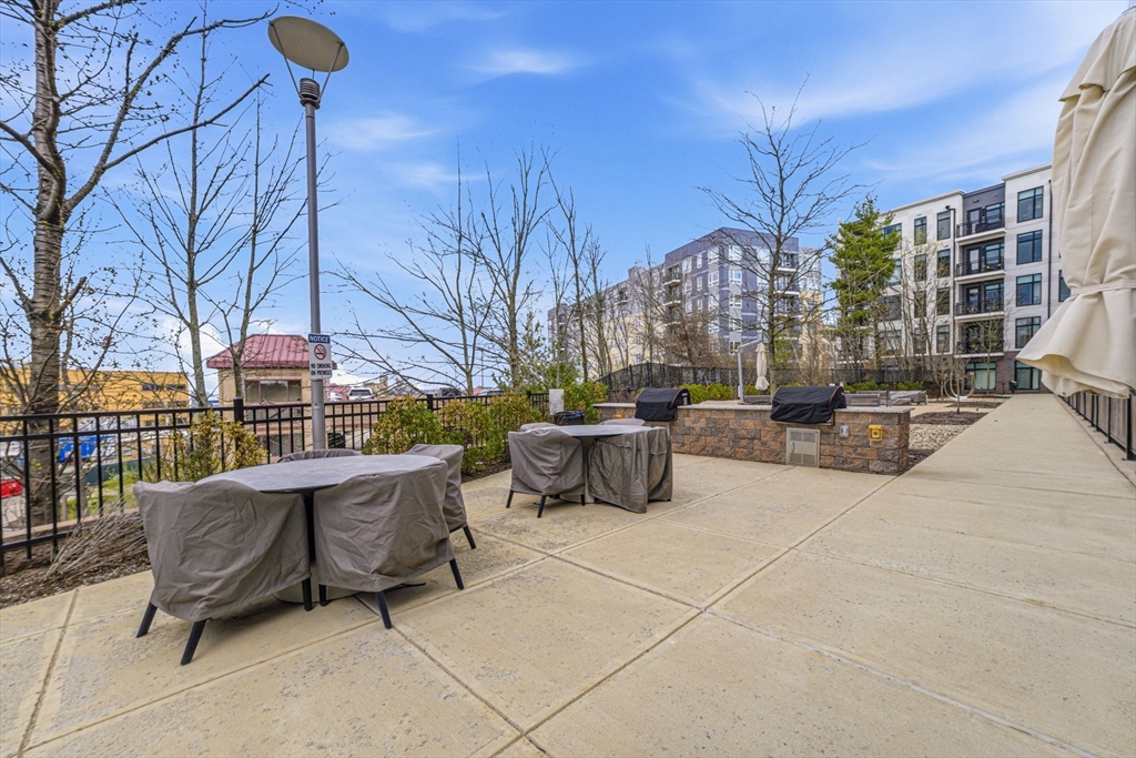 191 Washington Street, Unit 413 Boston, MA 02135 - Photo 12 of 40 a roof deck with table and chairs and potted plants