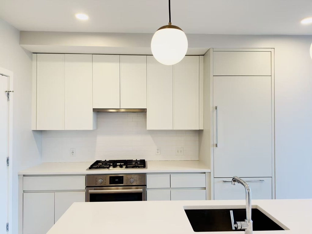 191 Washington Street, Unit 413 Boston, MA 02135 - Photo 15 of 40 a kitchen with a sink and a stove