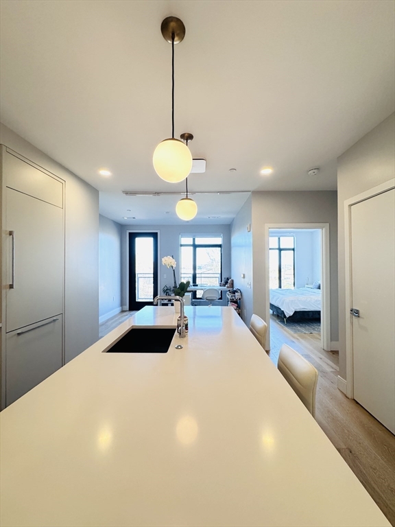 191 Washington Street, Unit 413 Boston, MA 02135 - Photo 16 of 40 a bedroom with a bed and a chandelier