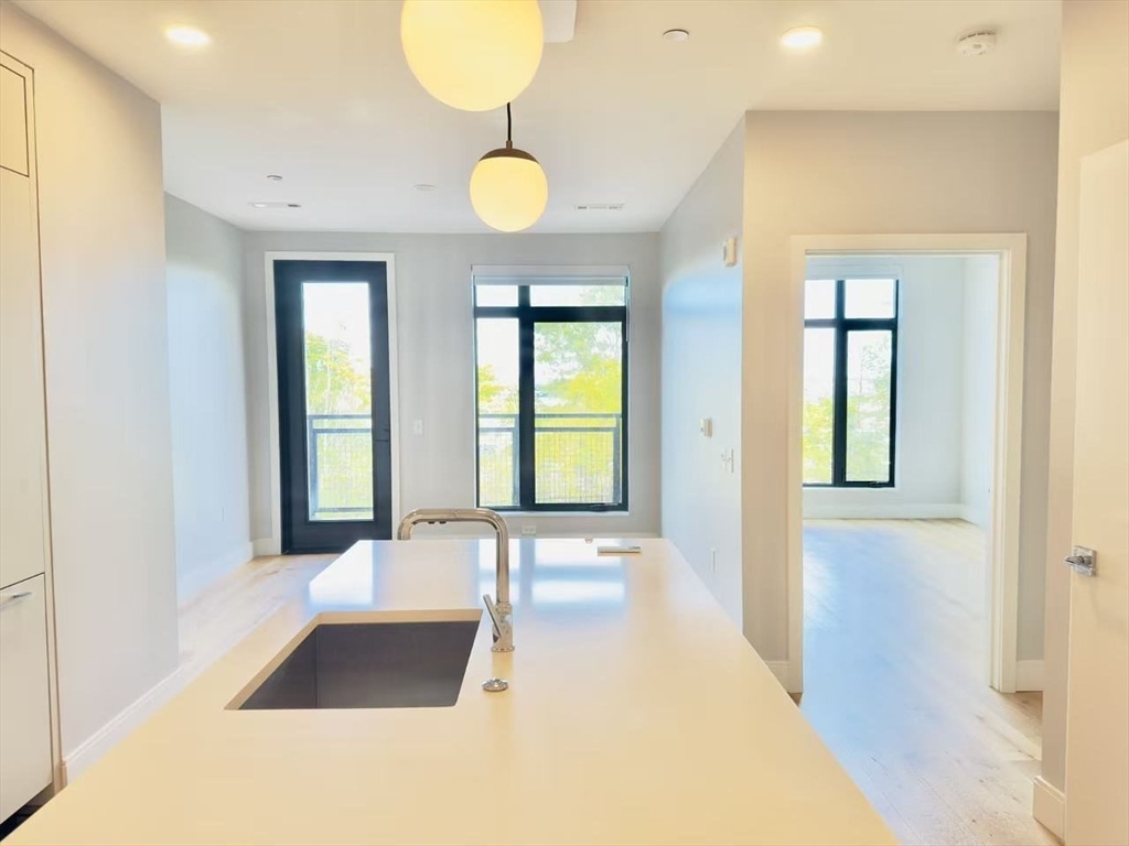 191 Washington Street, Unit 413 Boston, MA 02135 - Photo 17 of 40 a view of an empty room with window and wooden floor