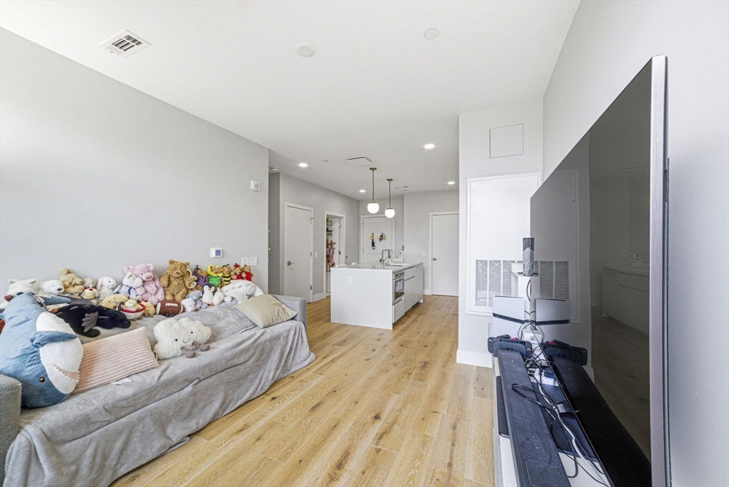 191 Washington Street, Unit 413 Boston, MA 02135 - Photo 20 of 40 a living room with furniture and a wooden floor