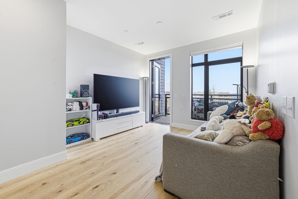 191 Washington Street, Unit 413 Boston, MA 02135 - Photo 21 of 40 a living room with furniture and a flat screen tv