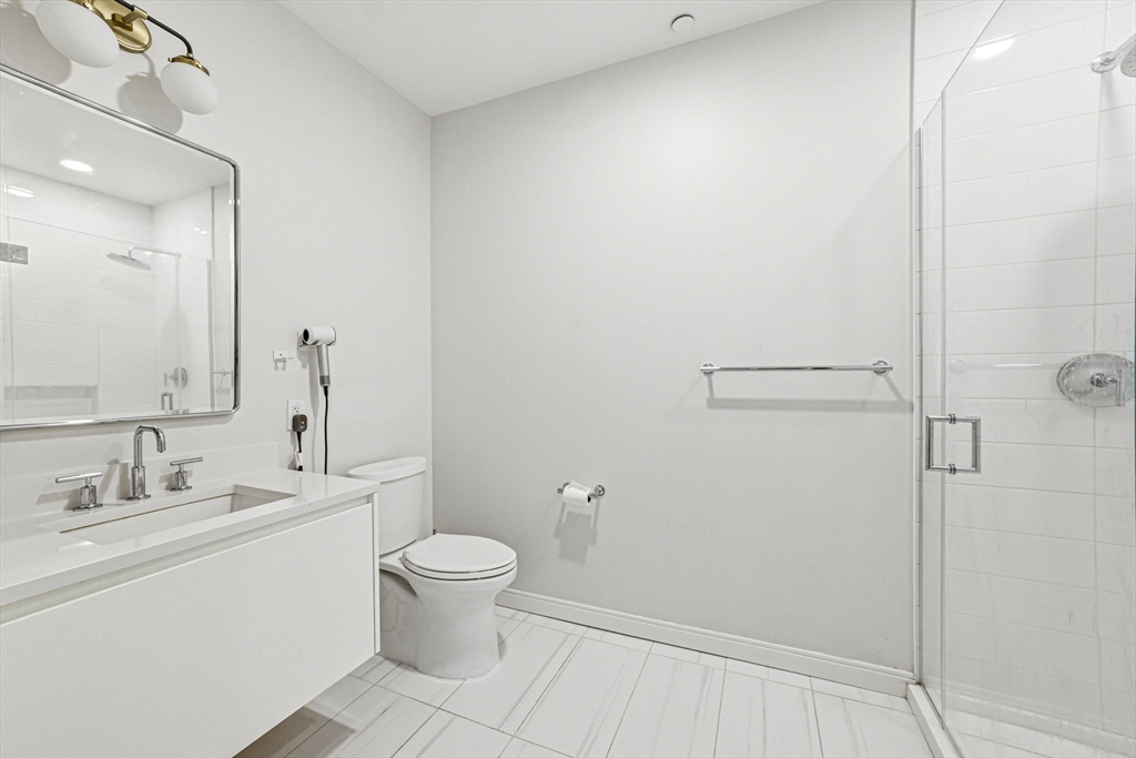 191 Washington Street, Unit 413 Boston, MA 02135 - Photo 22 of 40 a bathroom with a toilet sink and a mirror