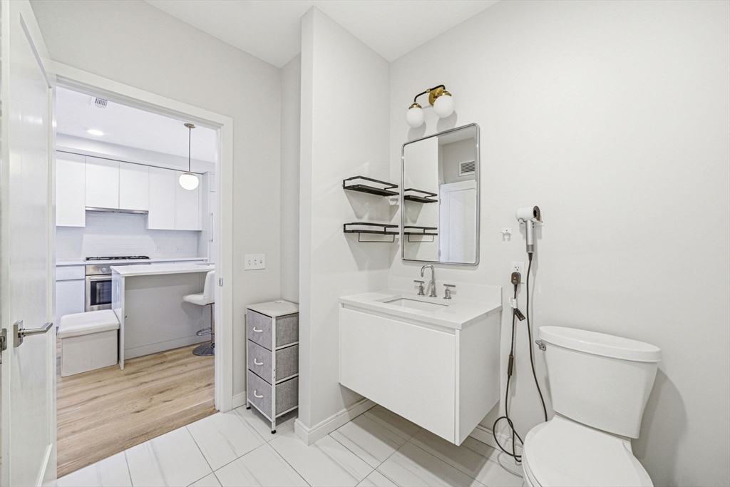 191 Washington Street, Unit 413 Boston, MA 02135 - Photo 23 of 40 a bathroom with a toilet sink and mirror