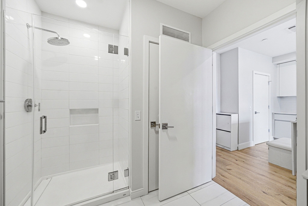 191 Washington Street, Unit 413 Boston, MA 02135 - Photo 24 of 40 a bathroom with a shower and a glass door