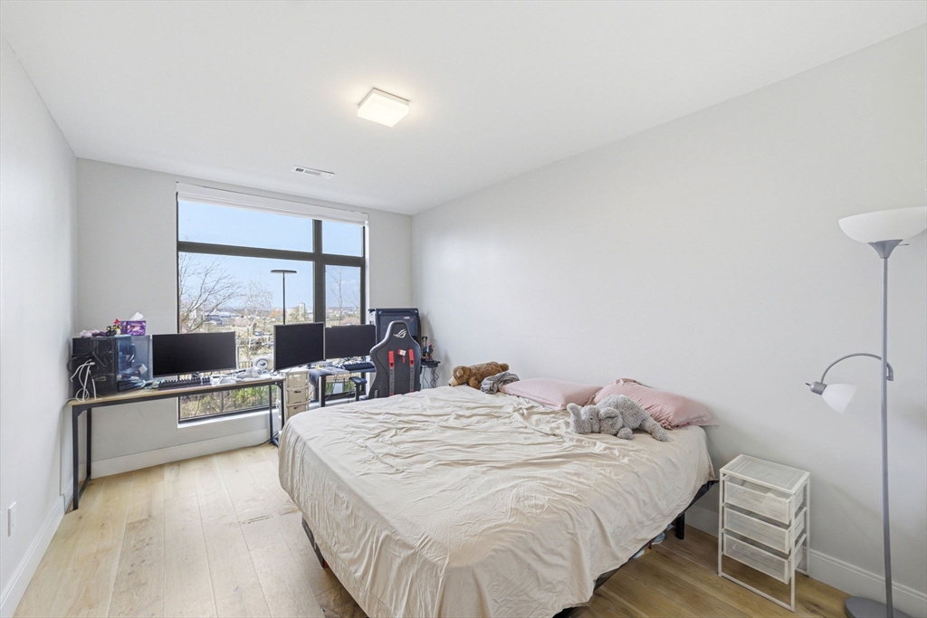 191 Washington Street, Unit 413 Boston, MA 02135 - Photo 27 of 40 a bed room with a bed window and a table