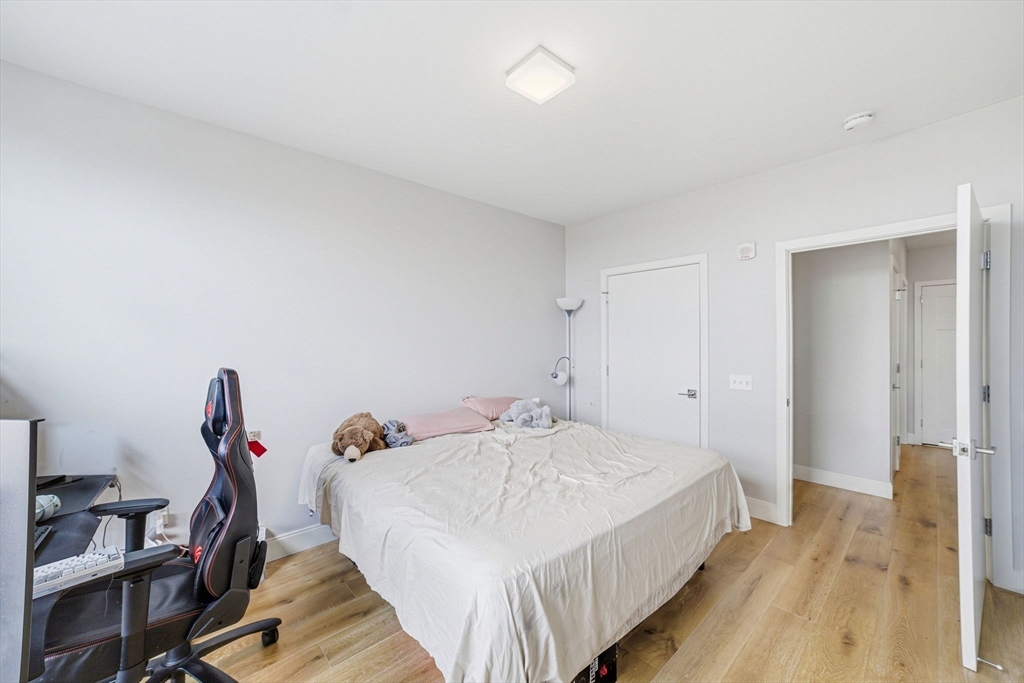 191 Washington Street, Unit 413 Boston, MA 02135 - Photo 28 of 40 a bedroom with a bed and a table