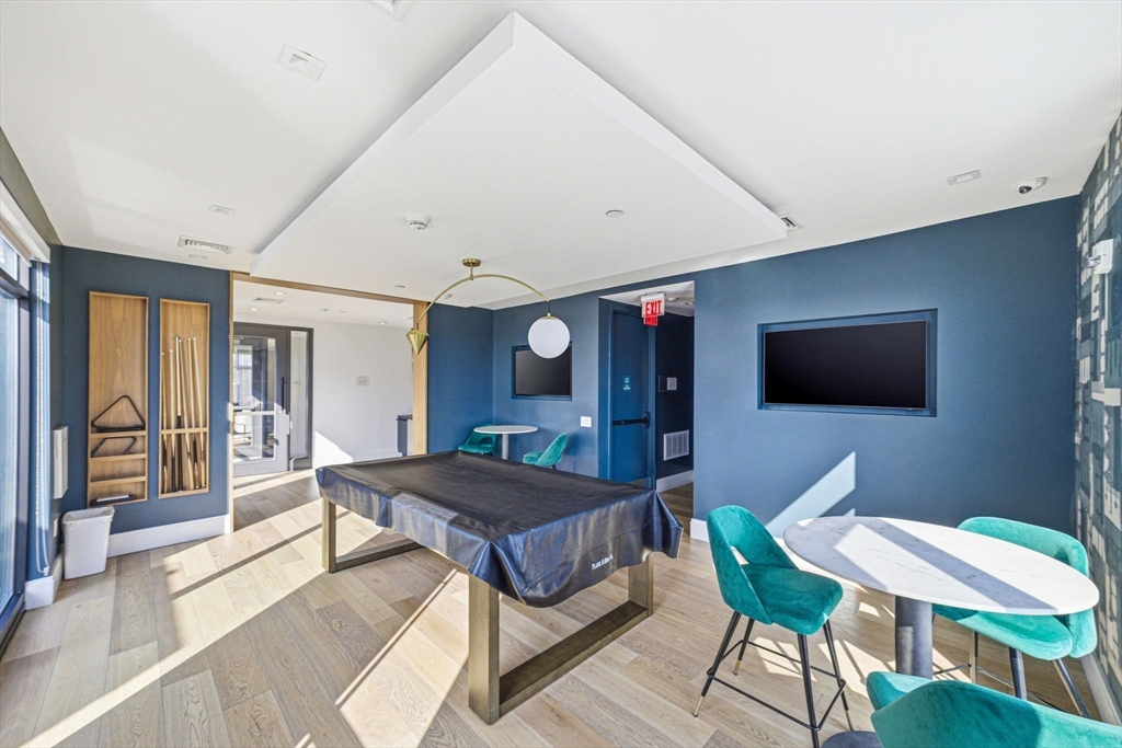 191 Washington Street, Unit 413 Boston, MA 02135 - Photo 32 of 40 a bedroom with a bed and wooden floor