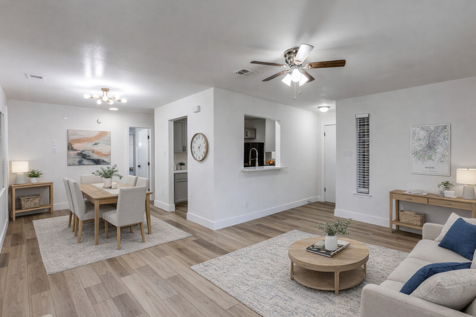 Living room with light wood-style floors, ceiling fan, and a chandelier