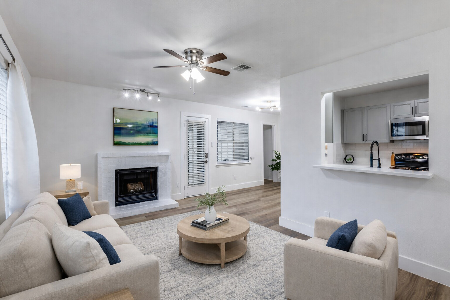 1845 River Crossing Circle, Unit A Austin, TX 78741 - Photo 11 of 31 Living area with a fireplace with raised hearth, ceiling fan, and wood finished floors