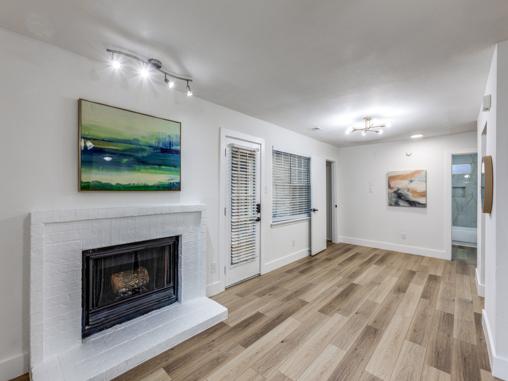 1845 River Crossing Circle, Unit A Austin, TX 78741 - Photo 14 of 31 Unfurnished living room with light wood-style floors and a brick fireplace
