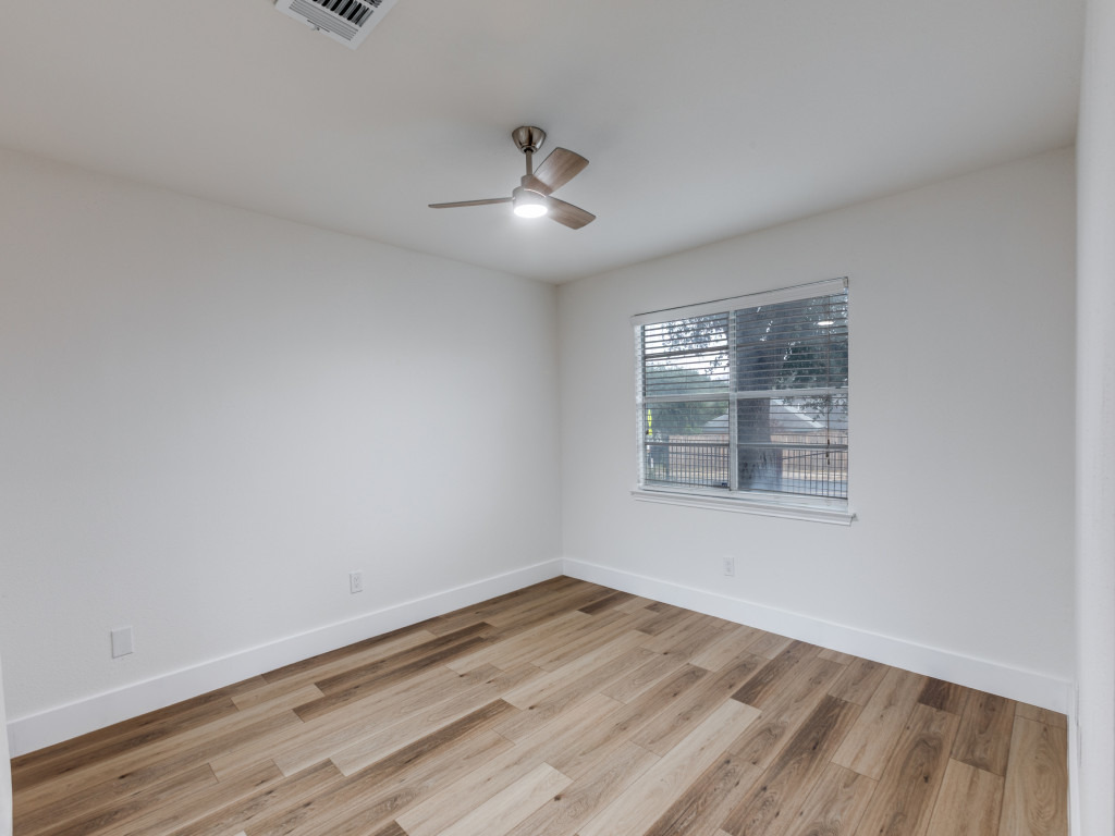 1845 River Crossing Circle, Unit A Austin, TX 78741 - Photo 21 of 31 Empty room featuring light wood-type flooring and ceiling fan