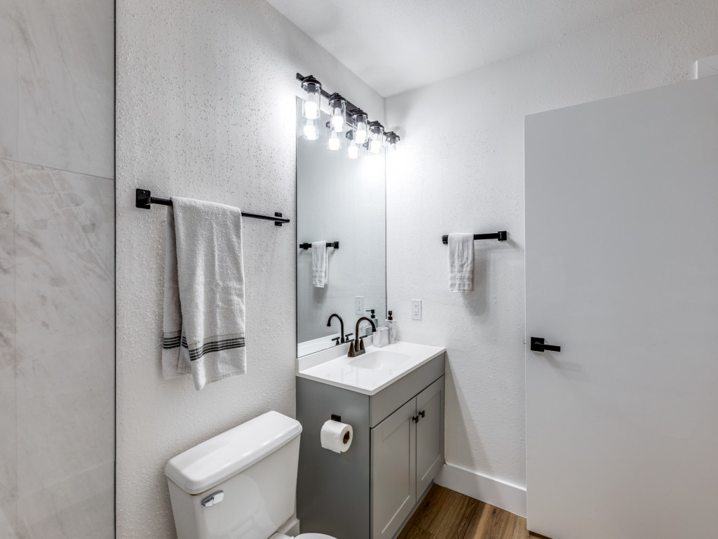 1845 River Crossing Circle, Unit A Austin, TX 78741 - Photo 24 of 31 Bathroom featuring vanity, dark wood-style flooring, and a textured wall