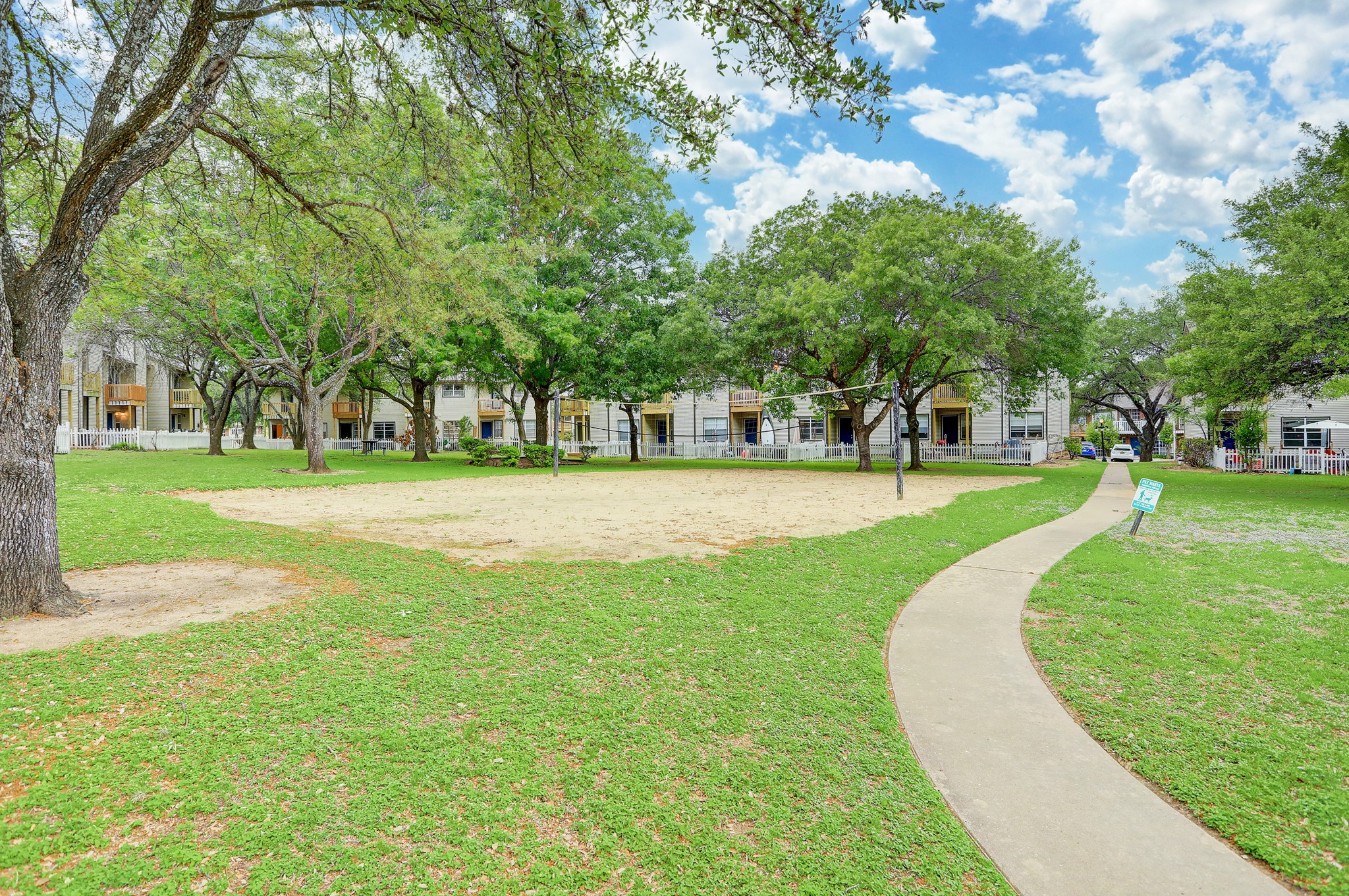 1845 River Crossing Circle, Unit A Austin, TX 78741 - Photo 30 of 31 View of property's community featuring a yard, volleyball court, and a residential view