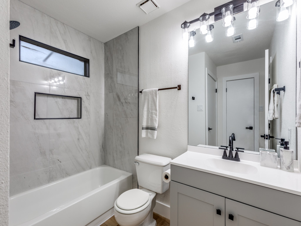 1845 River Crossing Circle, Unit A Austin, TX 78741 - Photo 5 of 31 Bathroom with vanity, shower / bath combination, and a textured wall