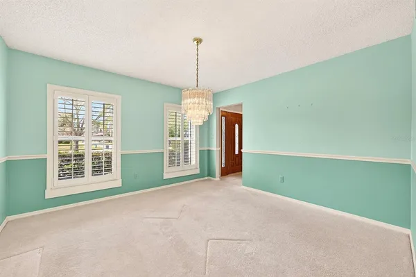 a view of an empty room with cabinet and a window