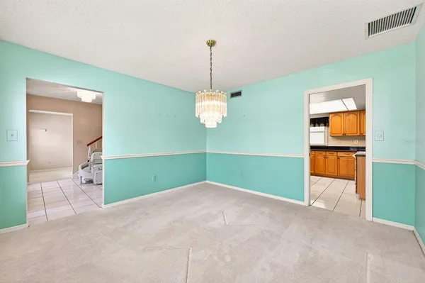 a spacious bedroom with a large bed and a chandelier fan