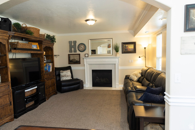 7532 North Castle Rock Road Eagle Mountain, UT 84005 - Photo 8 of 40 Main Floor Family room with crown molding, a fireplace, and carpet flooring. open to dining and kitchen