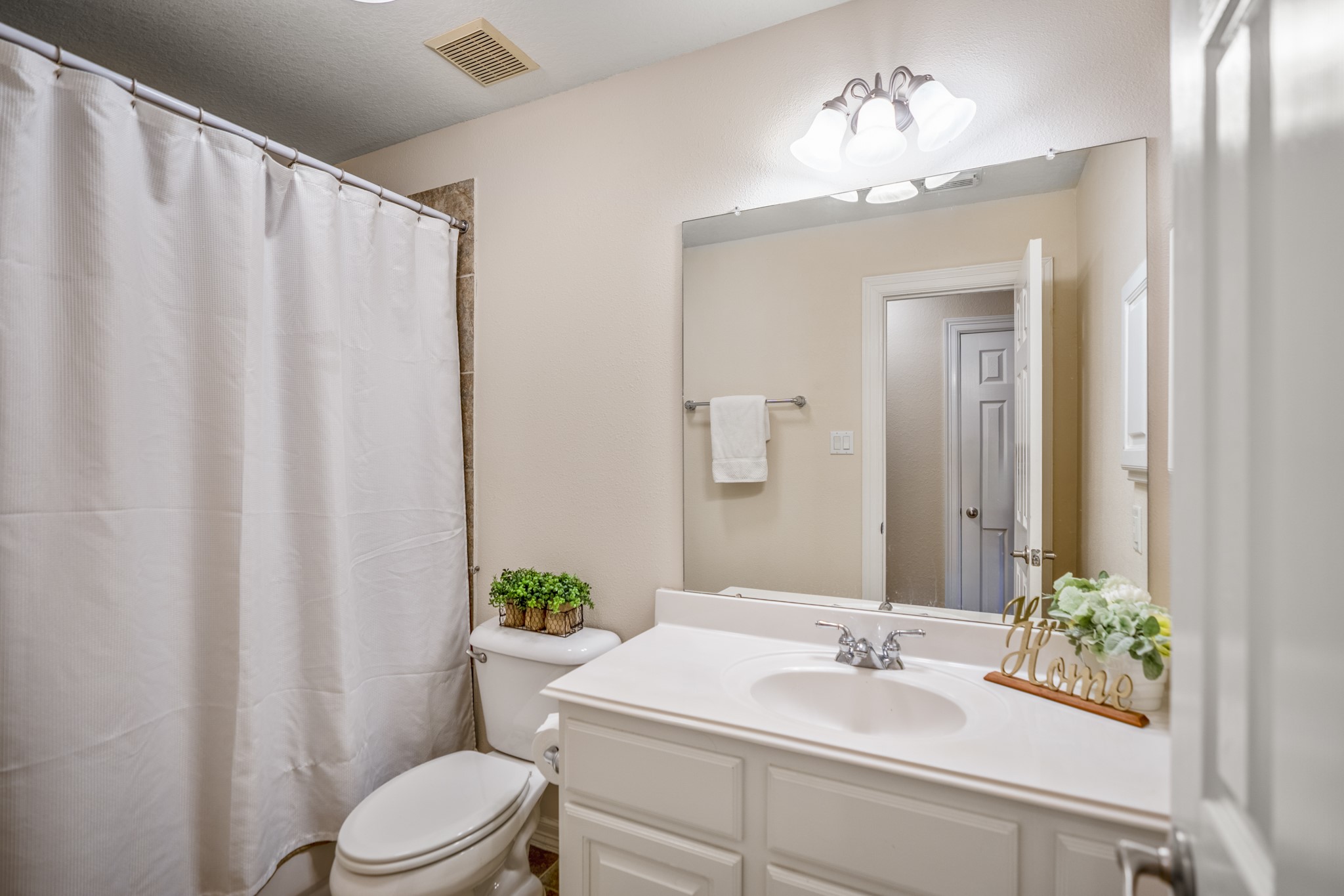 67 North Pentenwell Circle Spring, TX 77382 - Photo 29 of 50 a bathroom with a sink a toilet and shower curtain