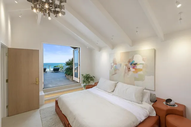 a bedroom with a large bed and a chandelier