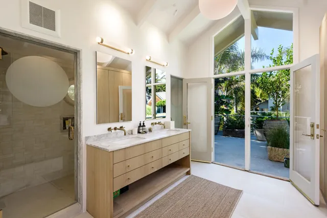 a bathroom with a double vanity sink mirror and shower