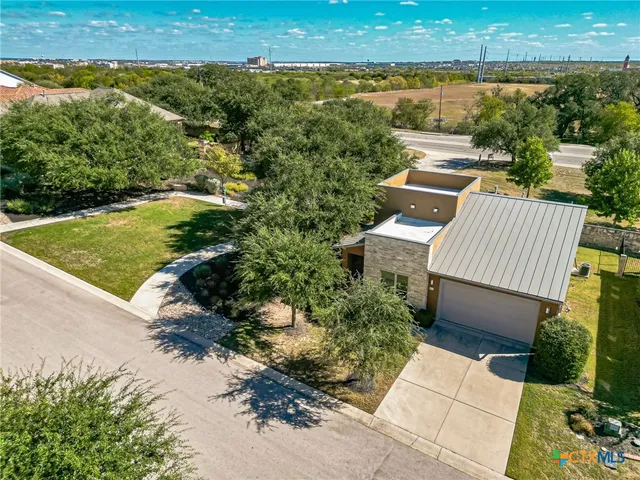 an aerial view of a house with a garden and lake view