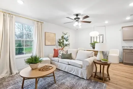 a living room with furniture and a wooden floor