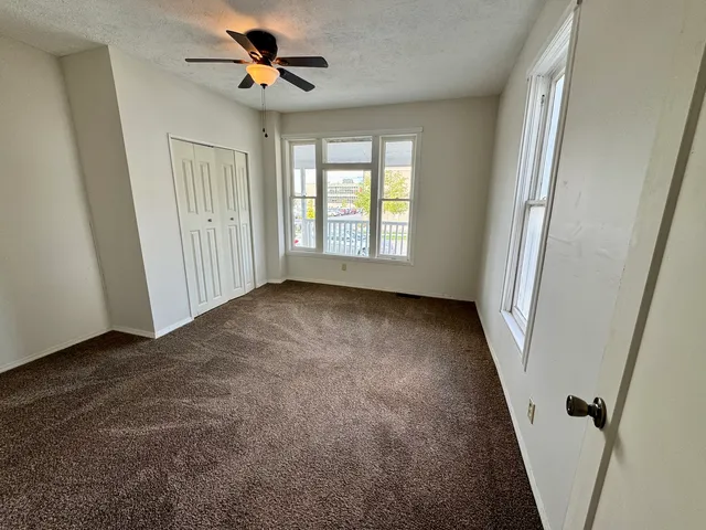 a view of a livingroom with a ceiling fan and window