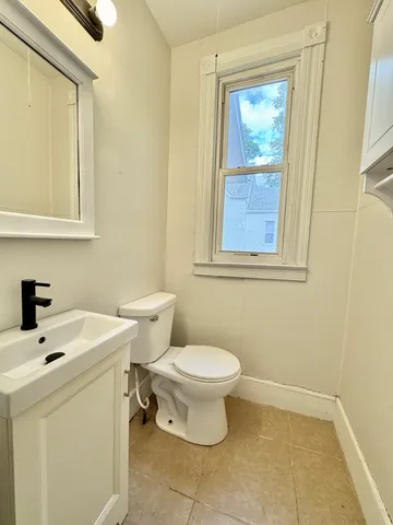 a bathroom with a sink a toilet and a window