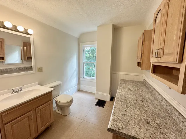 a bathroom with a sink a toilet and a mirror