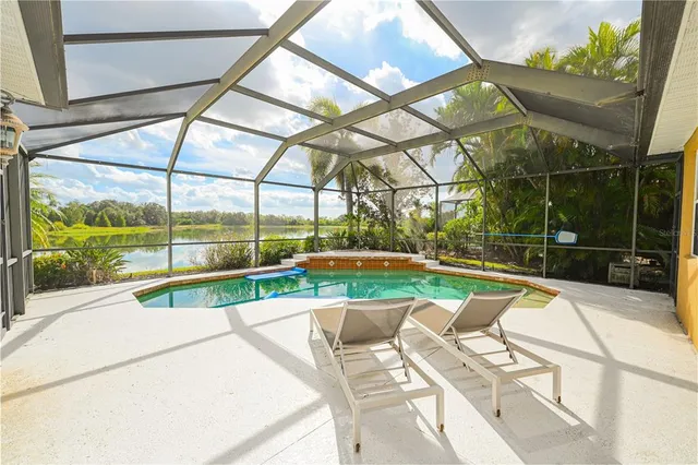 a white house with a yard and table and chairs under an umbrella