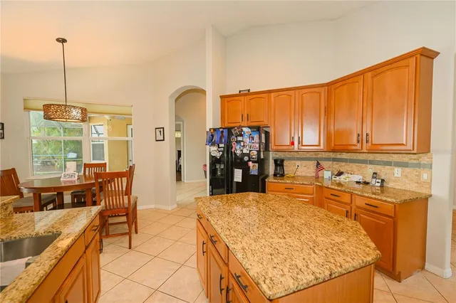 a living room with furniture kitchen view and a chandelier