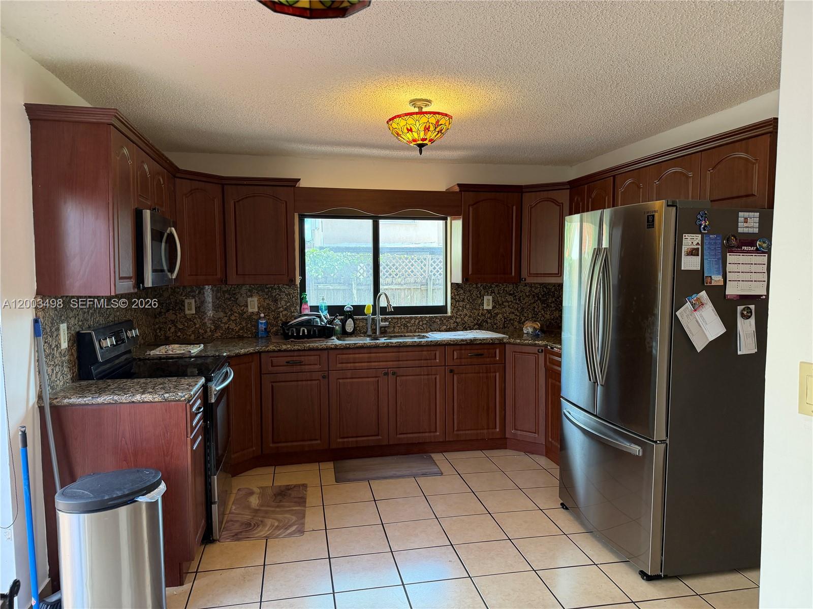 6010 Northwest 201st Lane Hialeah, FL 33015 - Photo 11 of 36 a kitchen with stainless steel appliances granite countertop a refrigerator and a stove top oven