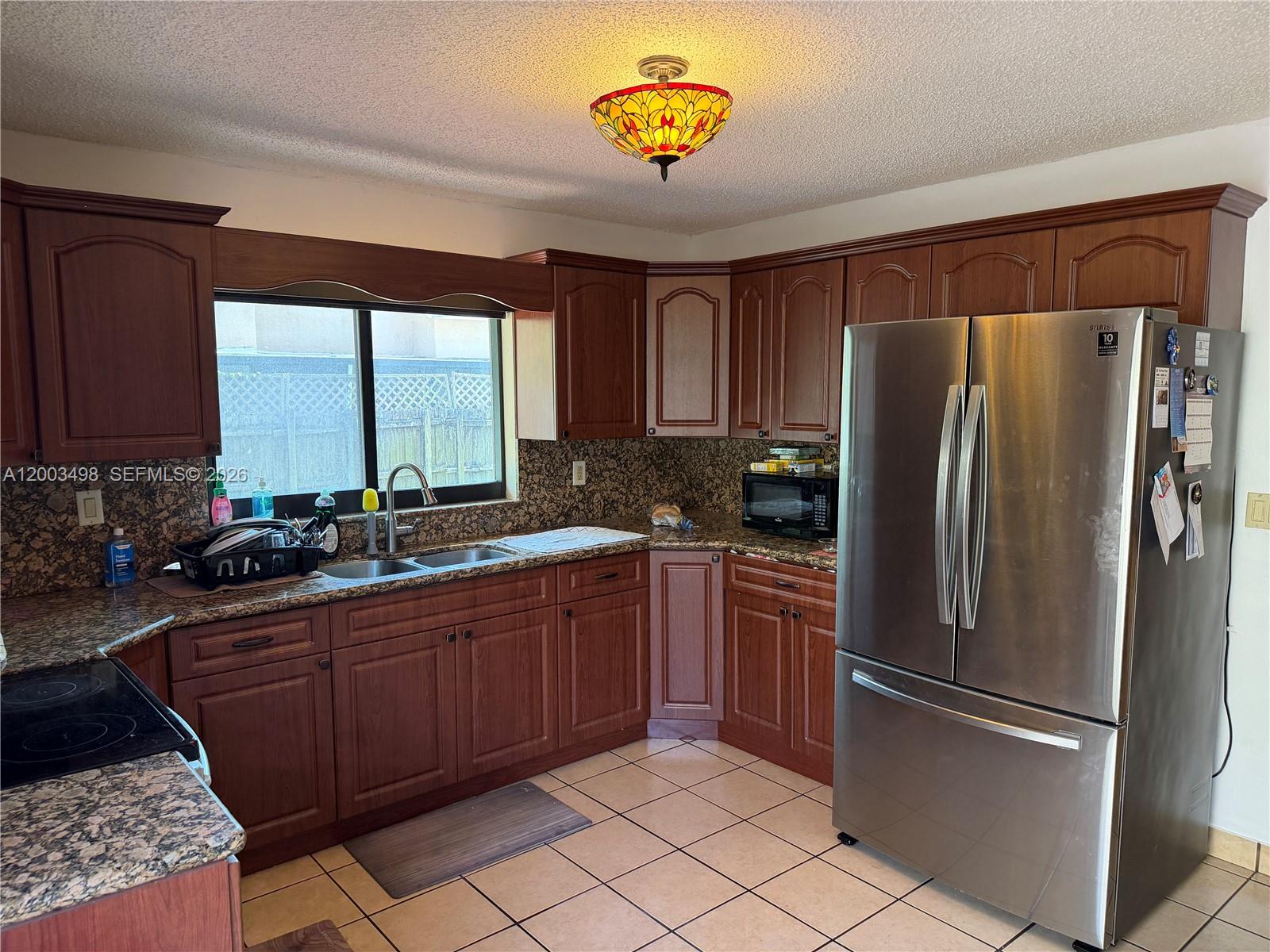 6010 Northwest 201st Lane Hialeah, FL 33015 - Photo 12 of 36 a kitchen with stainless steel appliances granite countertop a refrigerator and a sink