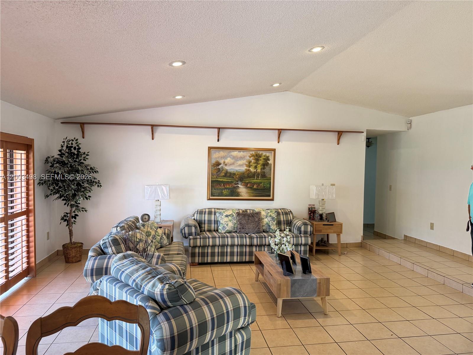6010 Northwest 201st Lane Hialeah, FL 33015 - Photo 16 of 36 a living room with furniture and a flat screen tv