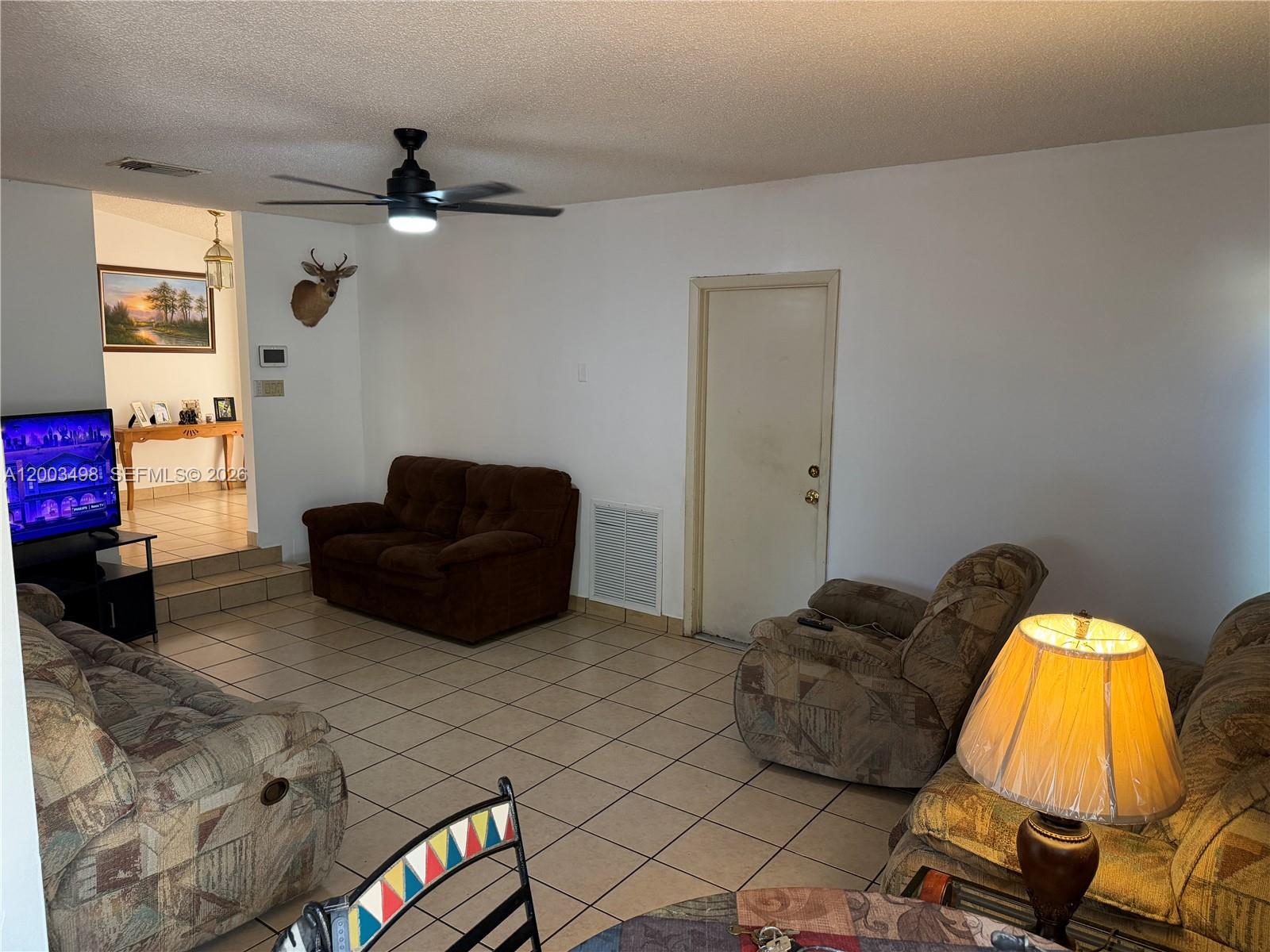 6010 Northwest 201st Lane Hialeah, FL 33015 - Photo 18 of 36 a living room with furniture and a flat screen tv