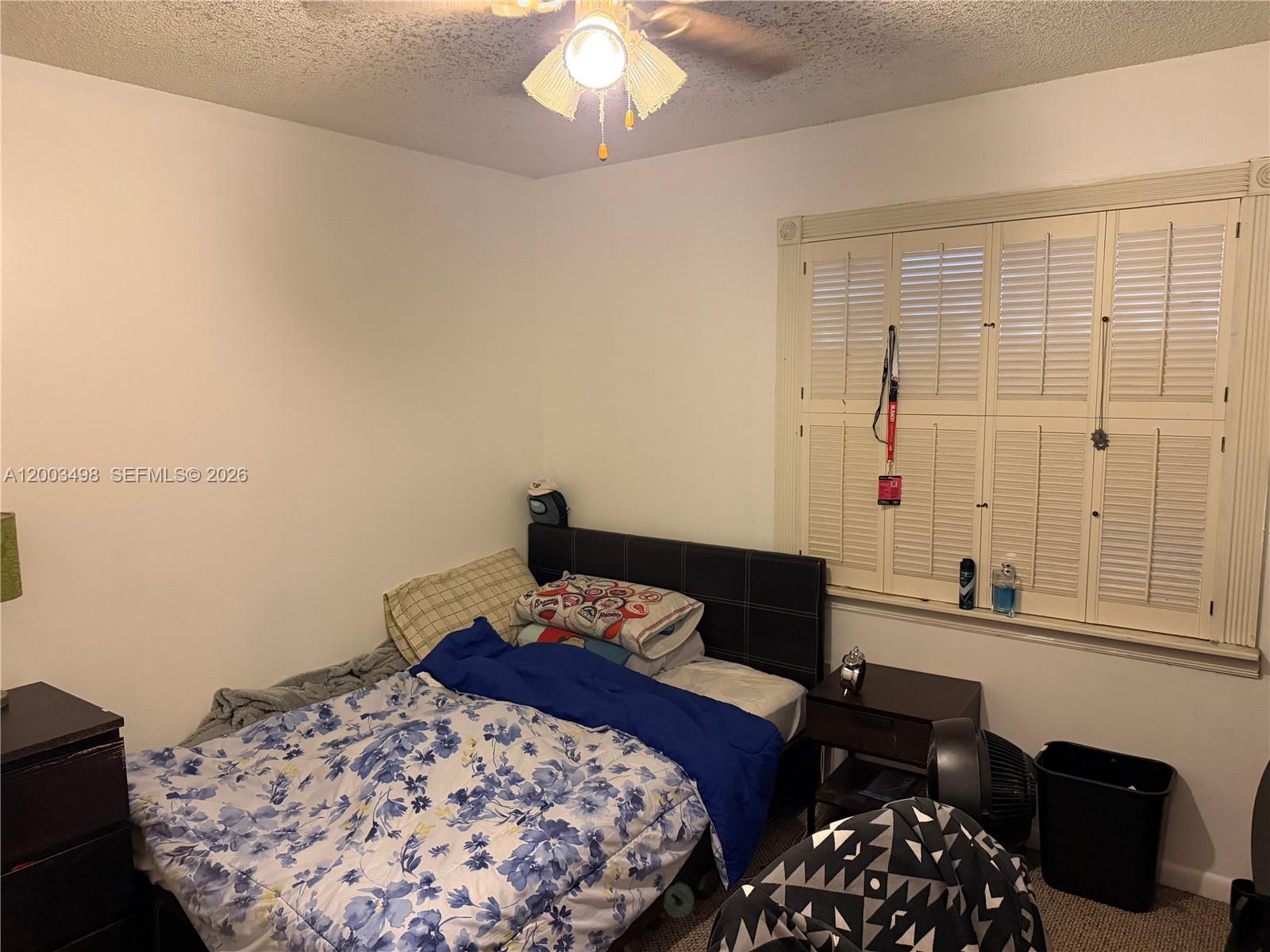 6010 Northwest 201st Lane Hialeah, FL 33015 - Photo 25 of 36 a bedroom with a bed and a chandelier