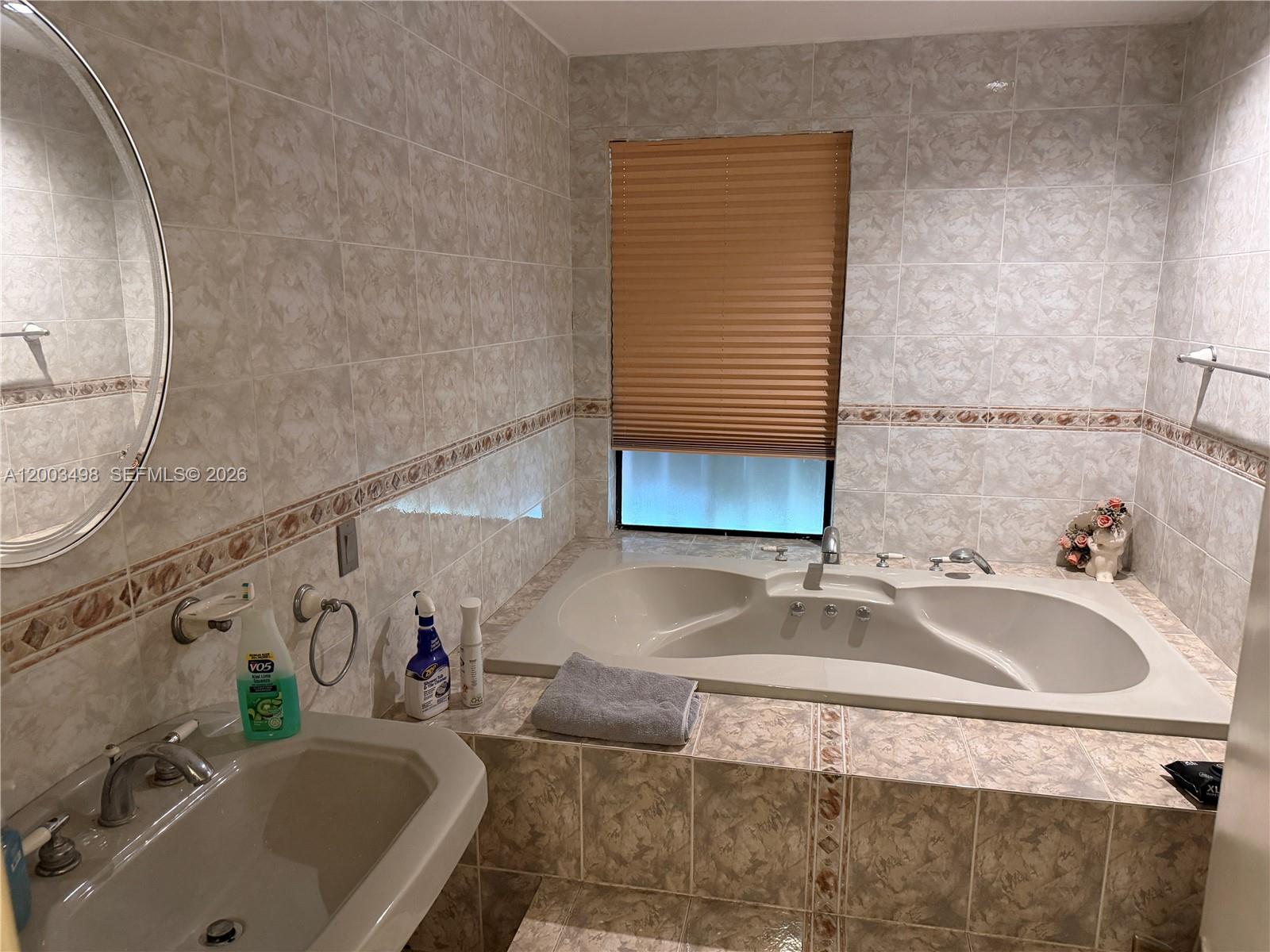 6010 Northwest 201st Lane Hialeah, FL 33015 - Photo 29 of 36 a bathroom with a tub sink and mirror