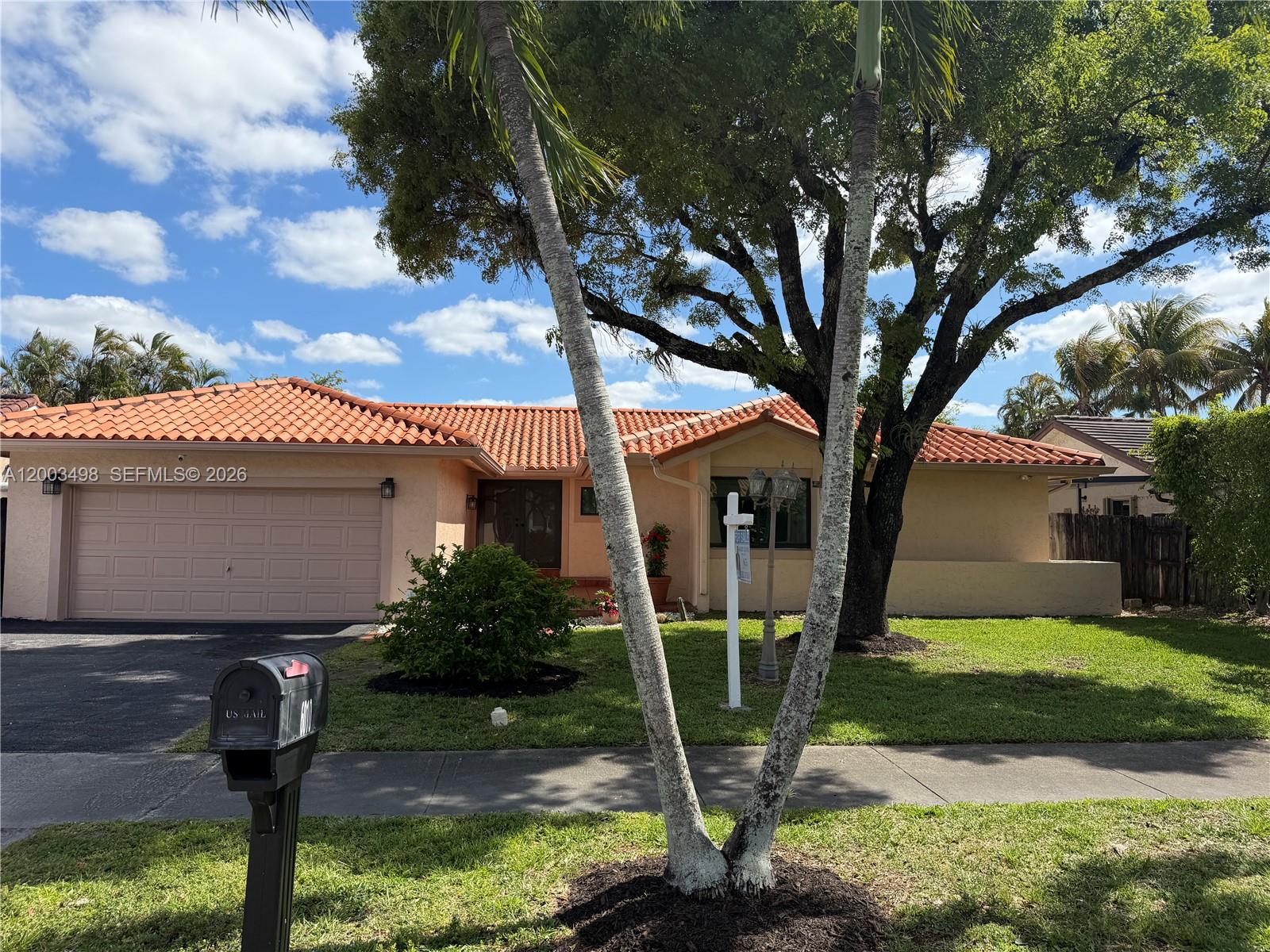 6010 Northwest 201st Lane Hialeah, FL 33015 - Photo 5 of 36 a front view of a house with garden