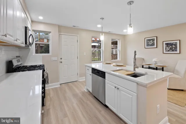 a kitchen with white cabinets and white appliances