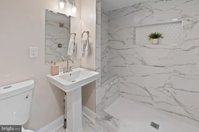 a bathroom with a sink a toilet and shower