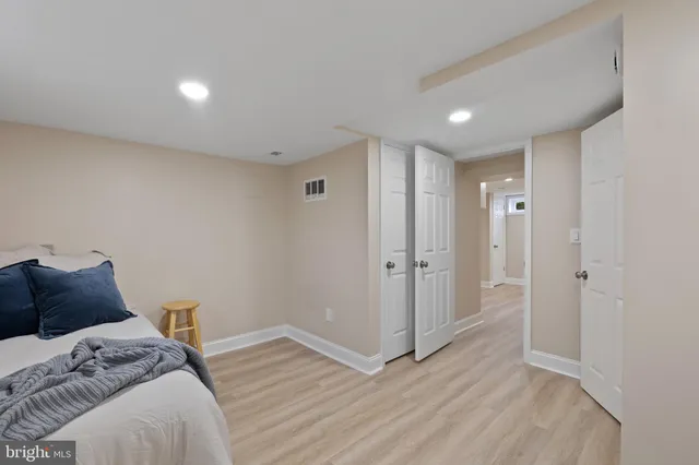 a bedroom with bed and wooden floor