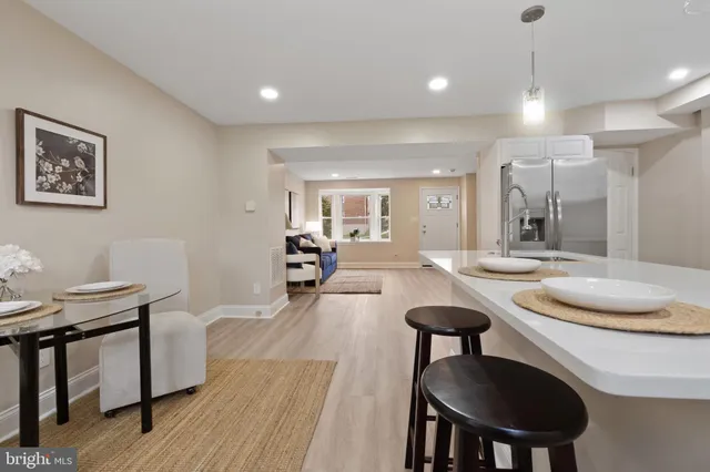 a living room with furniture a dining table and a chandelier
