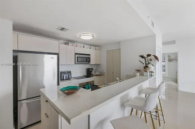 a kitchen with stainless steel appliances granite countertop a refrigerator and a stove top oven
