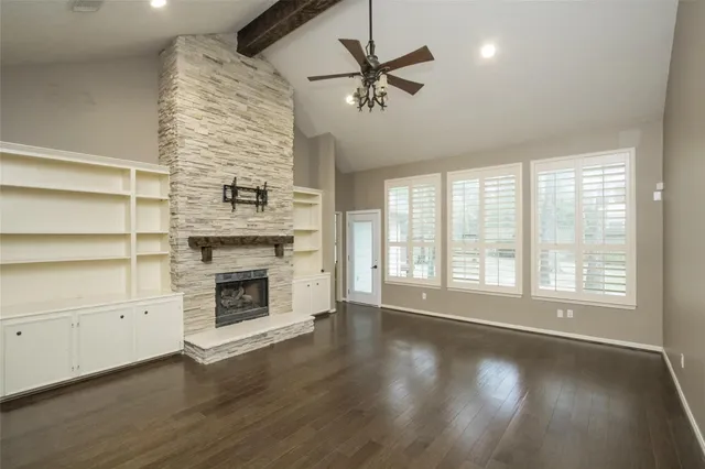 a view of an empty room with a fireplace and a window